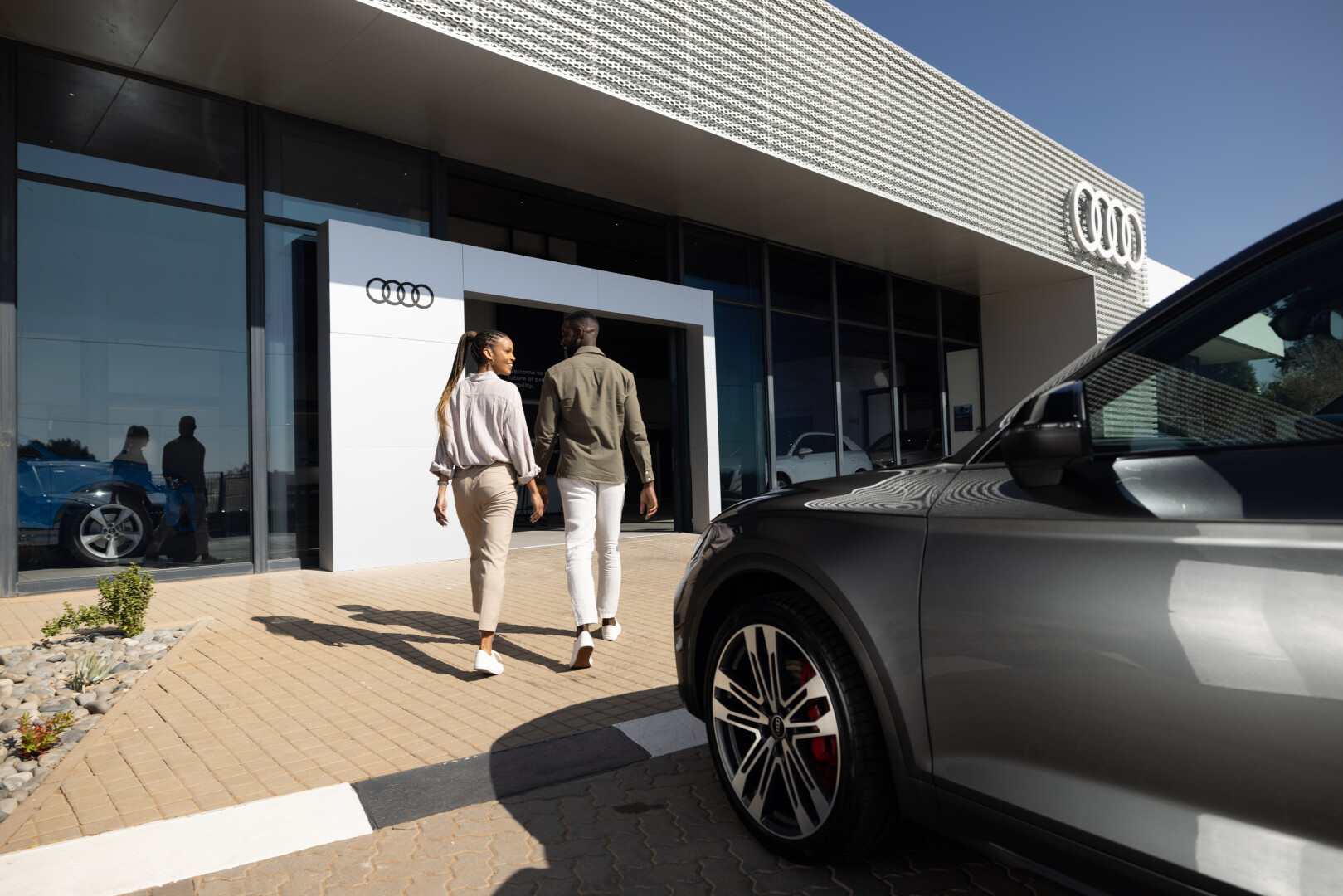 cOUPLE ABOUT TO ENTER AN aUDI DEALERSHIP