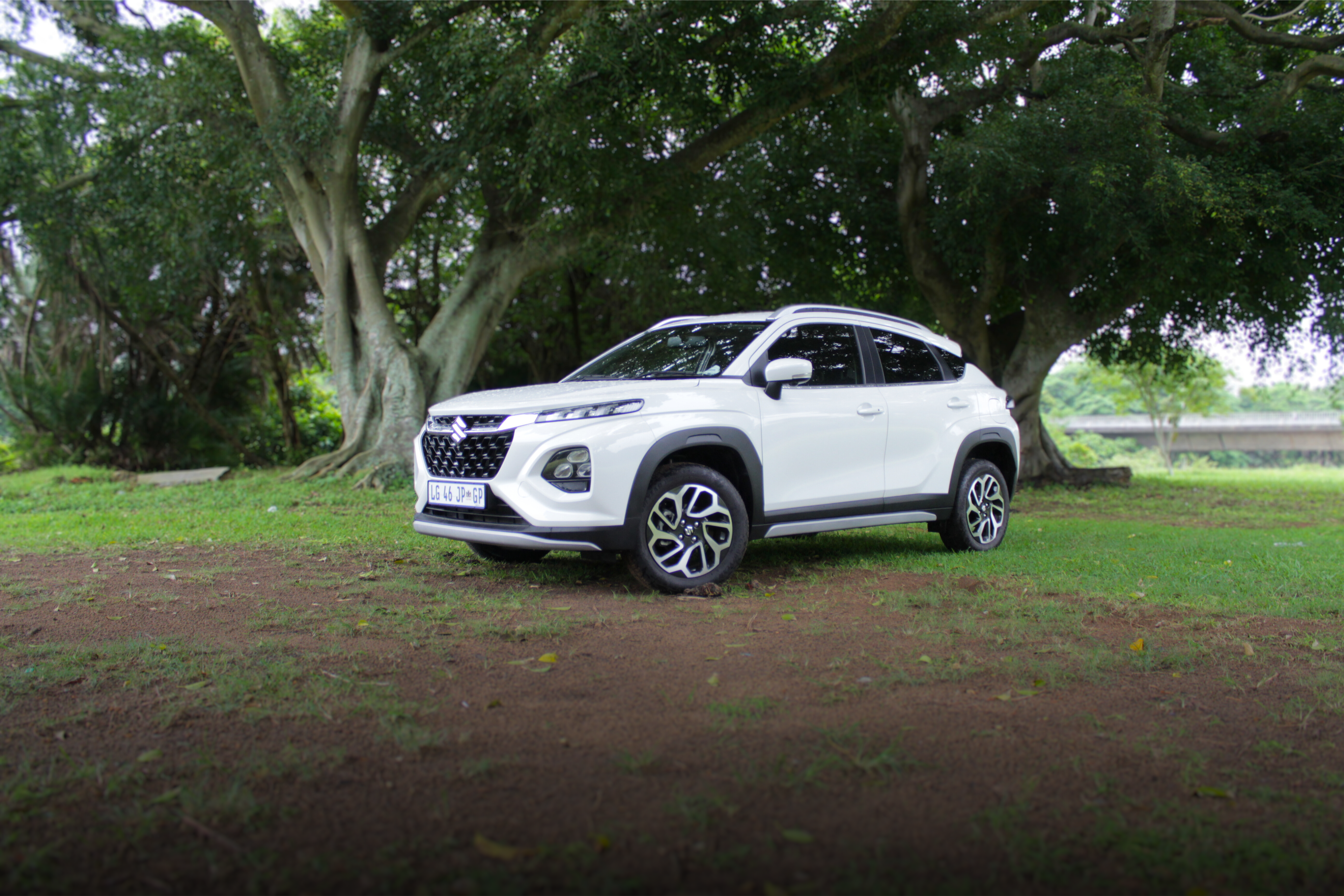 Front view of the Suzuki Fronx parked in fromt of some trees