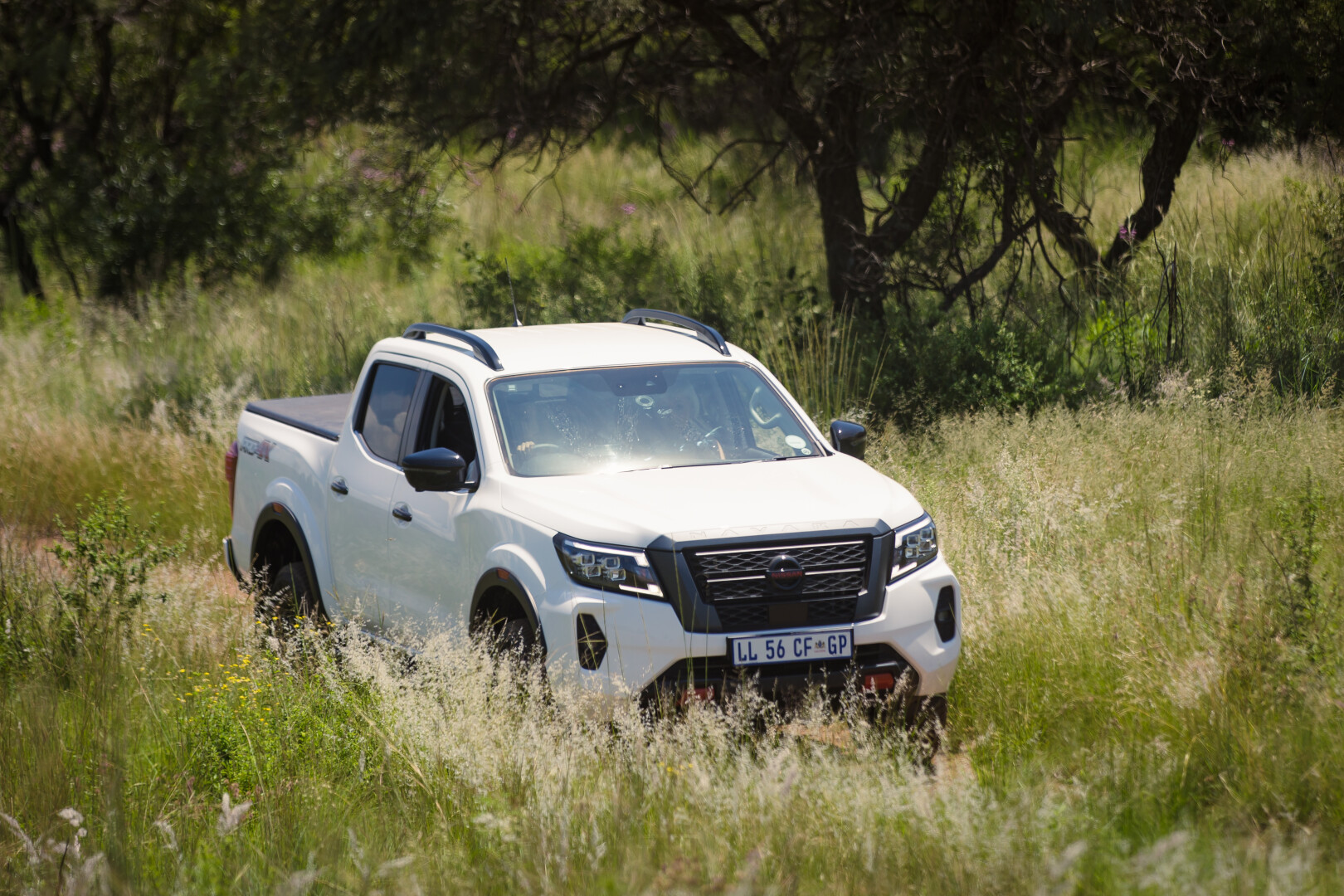 A white Nissan Navara driving in the Highvel bush