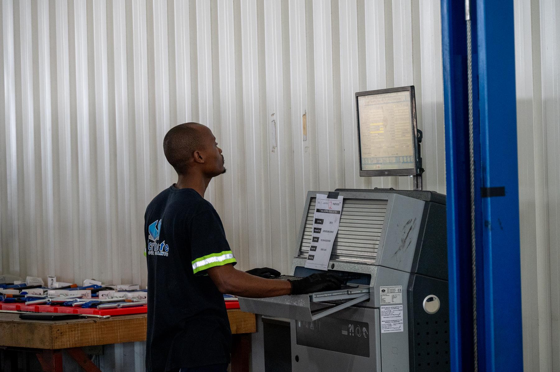 A worked operating a computer at the Mahindra factory