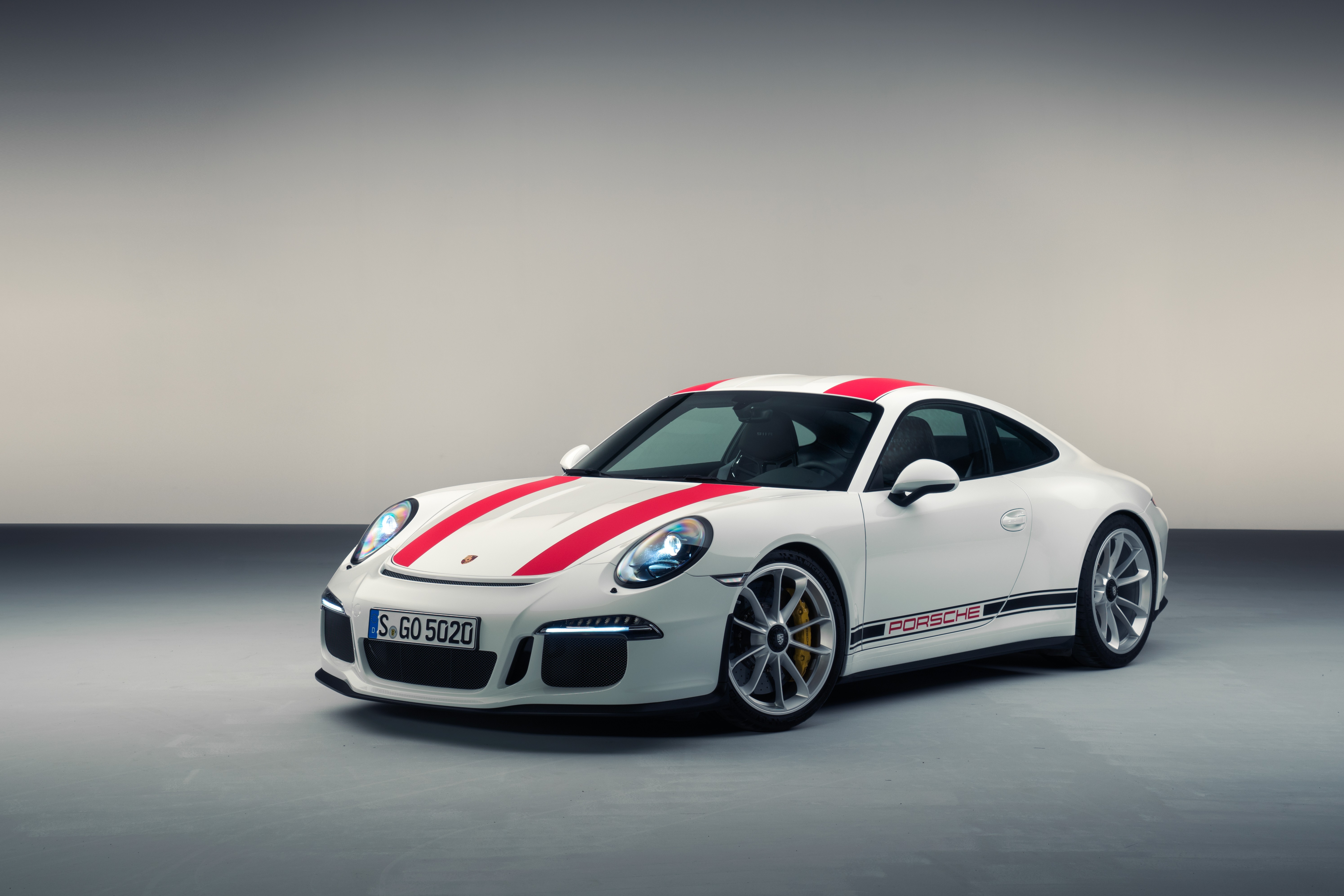 A white Porsche sports car with red racing stripes