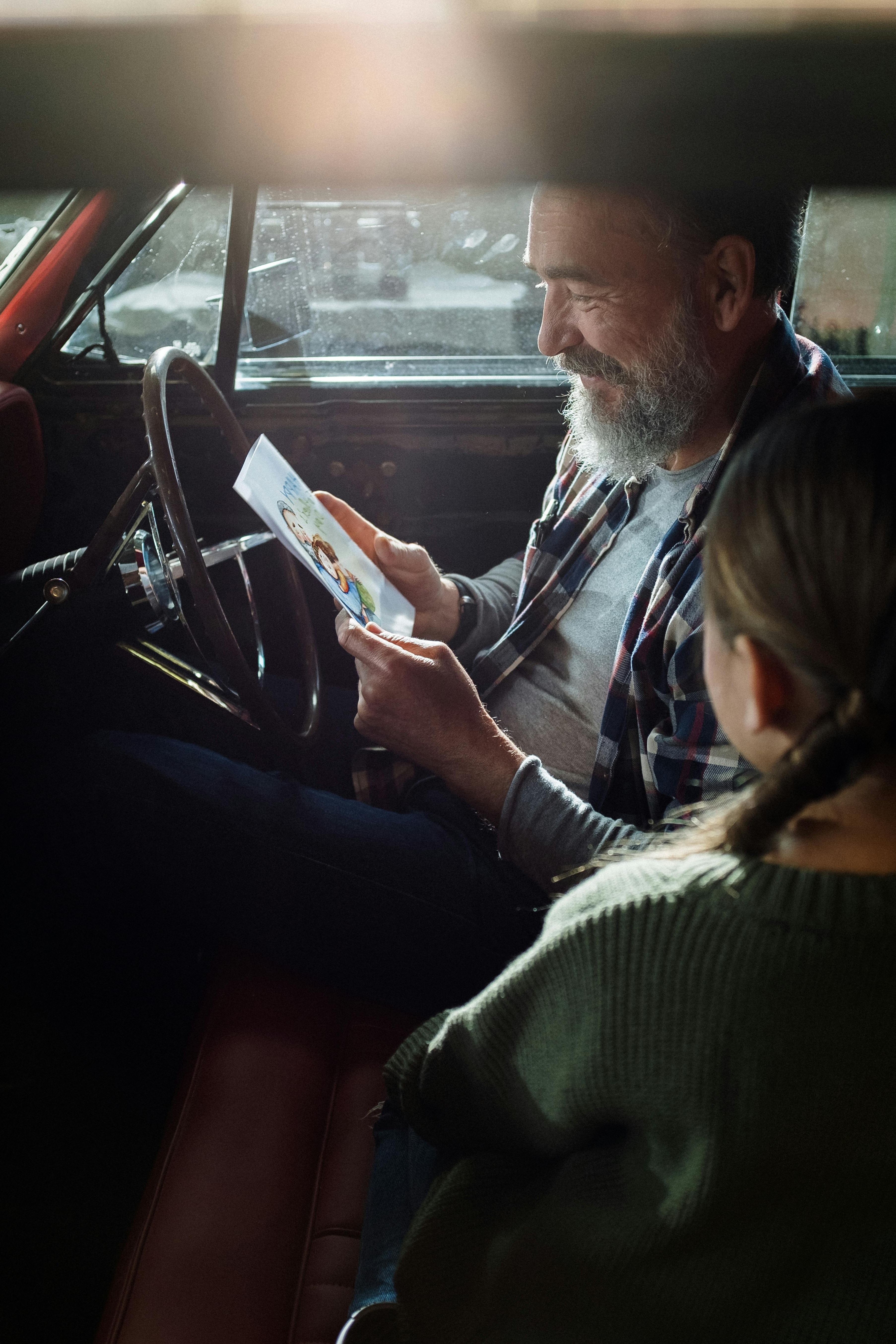 Man and daughter in car reading map
