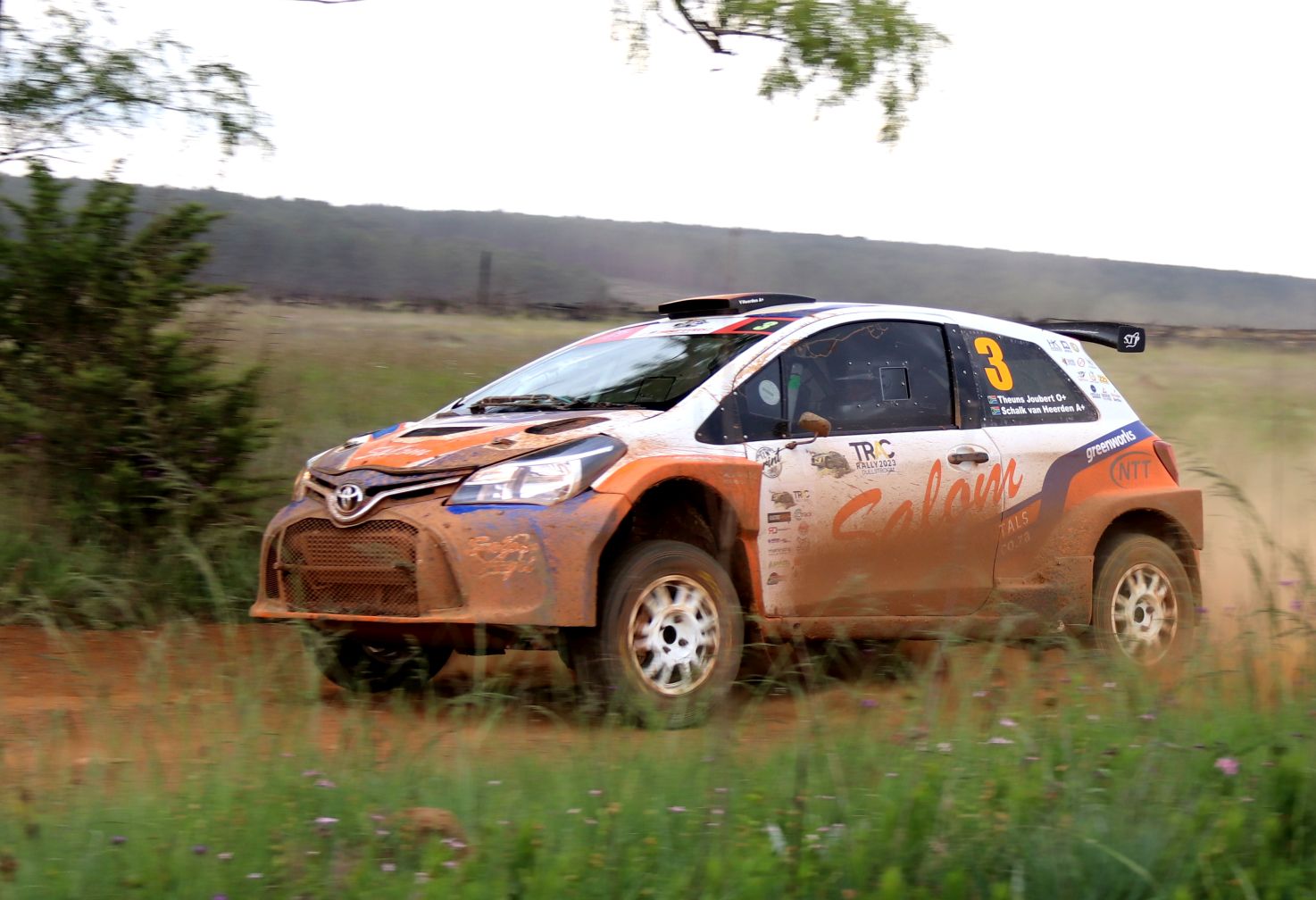 Toyota Yaris Rally car on a dirt road driving fat in a trail of dust