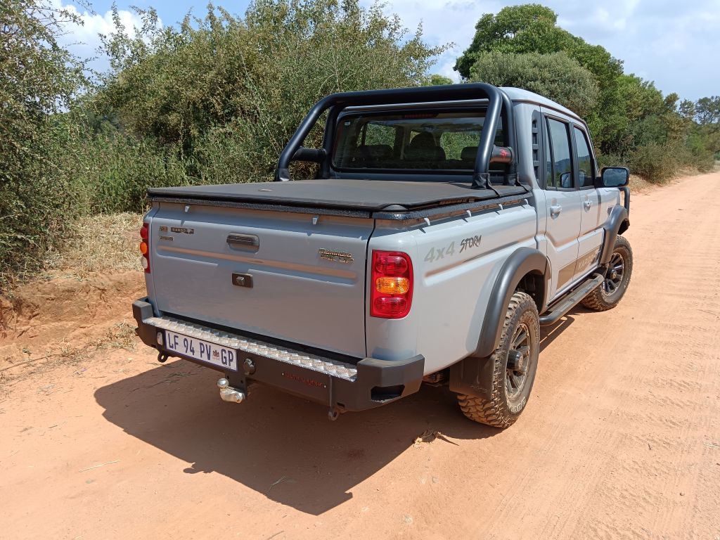 Rear view of a Grey Mahindra Karoo PikUp on a dirt road in the South African bushveld