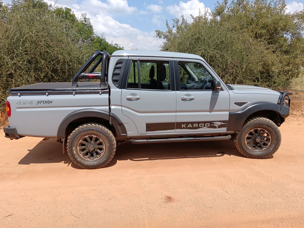 Grey Mahindra Karoo PikUp in the South African Bush on a dirt road in side view